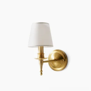 Antique brass wall sconce with linen shade - frontal studio view showing circular backplate and tapered drum shade