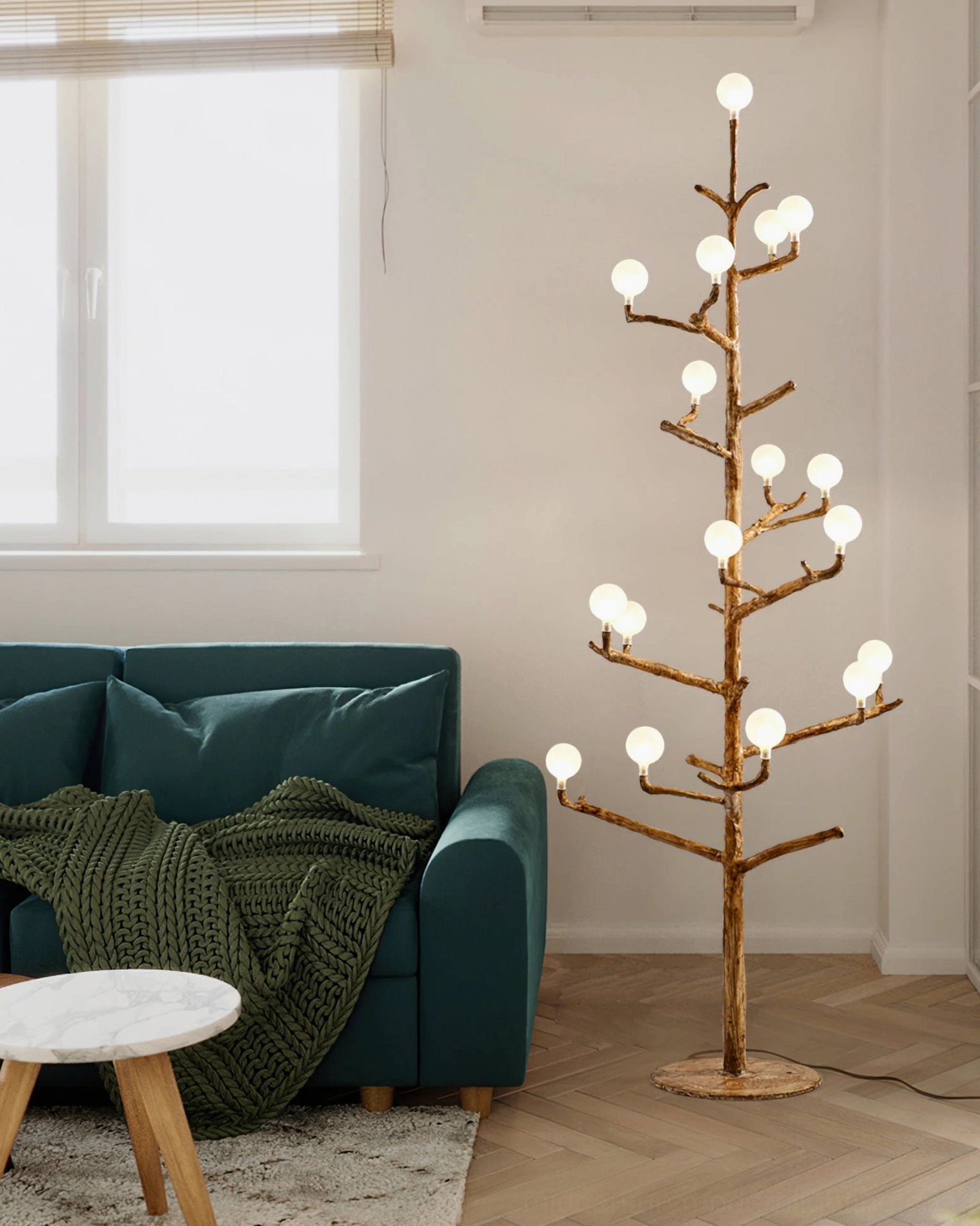 three-quarter side view of sculptural antler floor lamp beside dark green sofa, creating warm ambient lighting in contemporary living space
