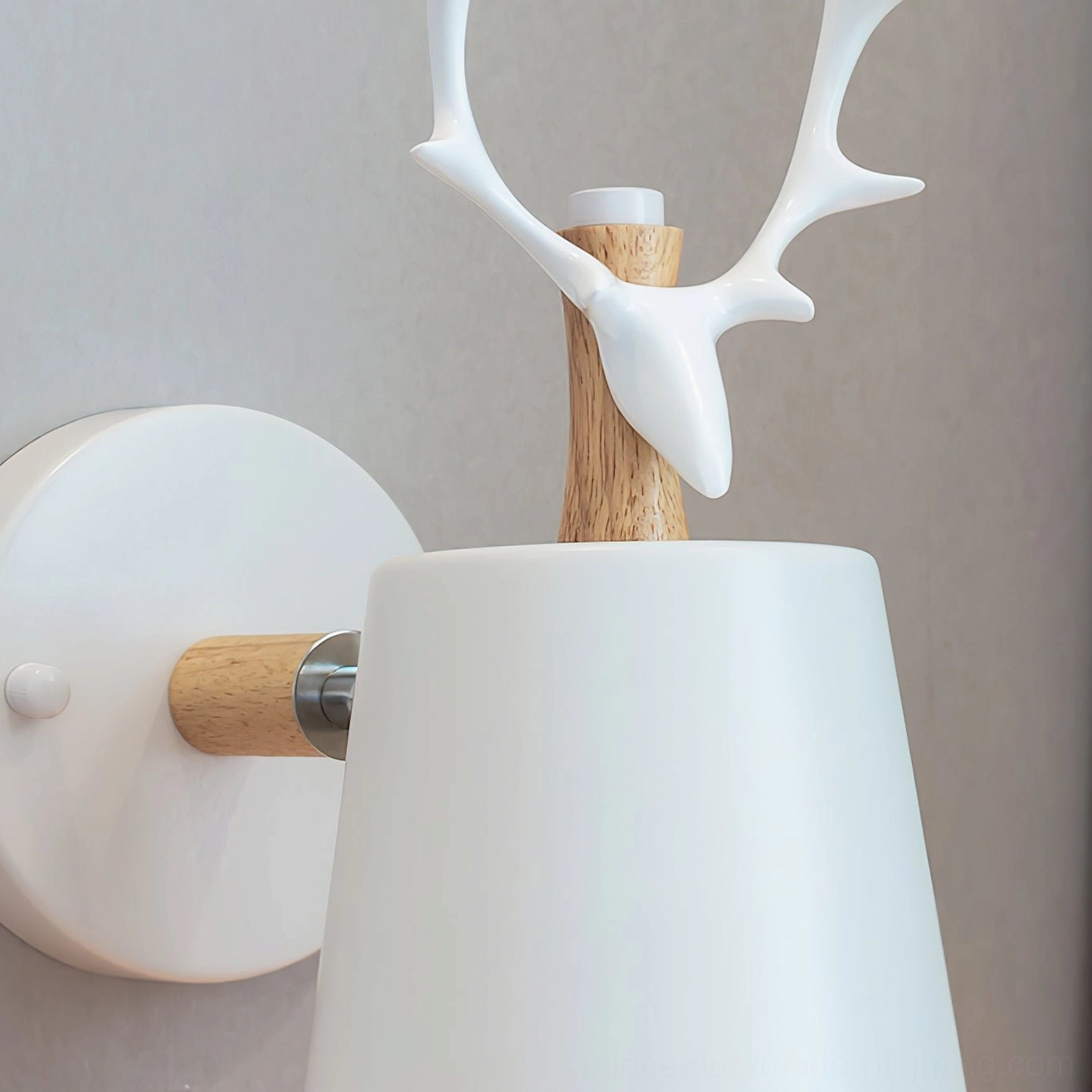 Close-up side view of sculptural resin antler crown on white matte wall lamp, minimalist Nordic aesthetics