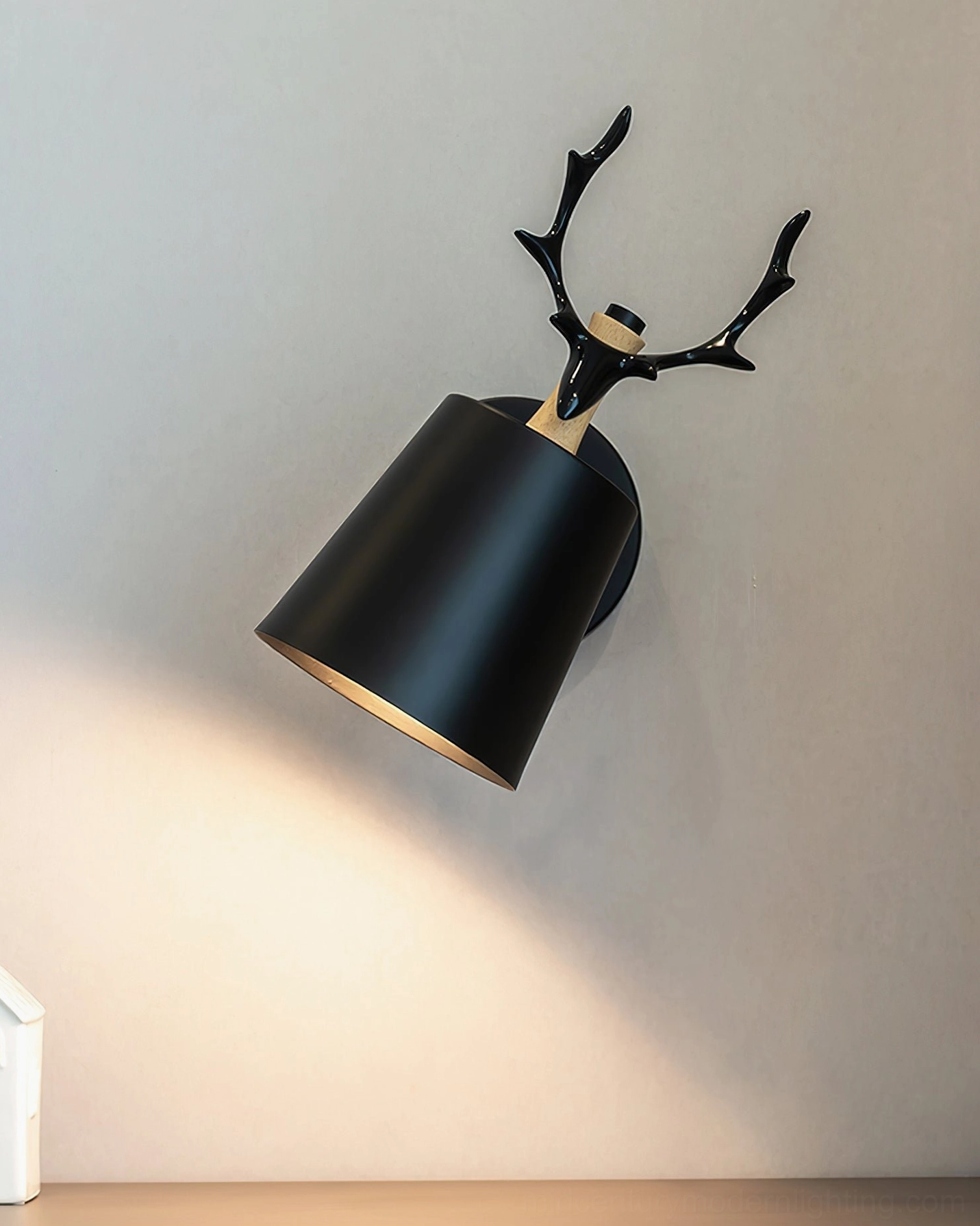 Sculptural antler wall lamp lighting detail, showing warm glow and resin antler silhouette in interior setting