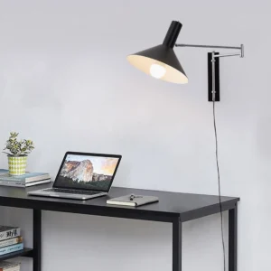 Black Anvia swing arm wall lamp mounted in modern home office workspace with exposed power cord