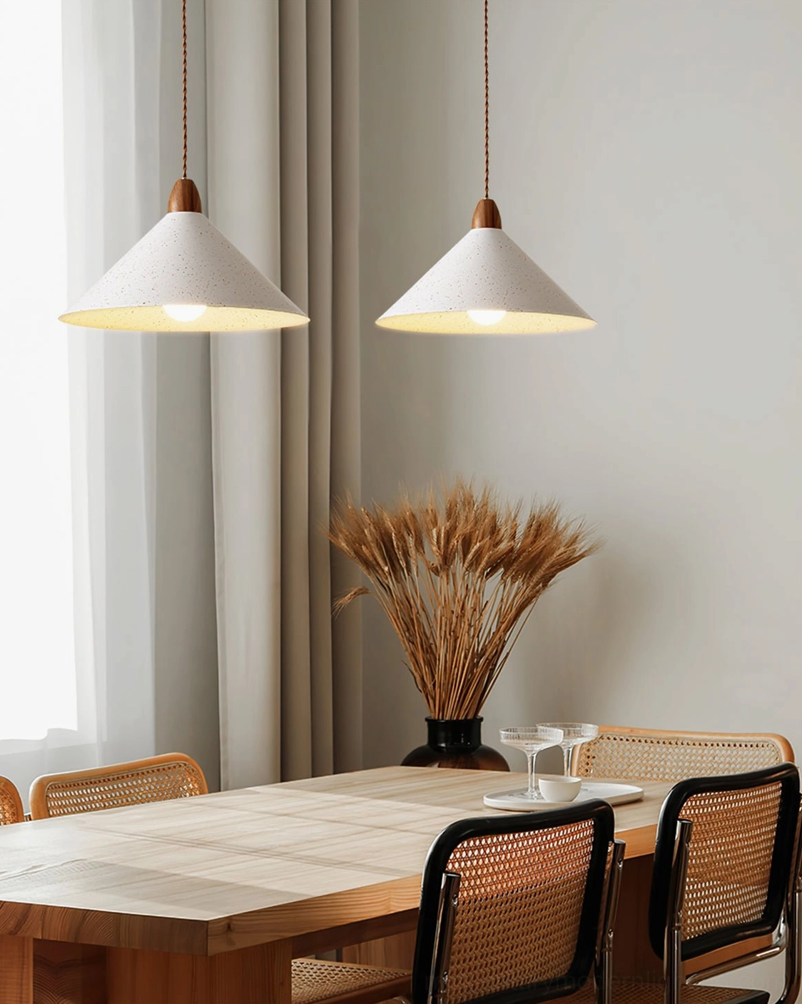 Anye pendant light illuminating Scandinavian dining table with wood accents and framed wall art