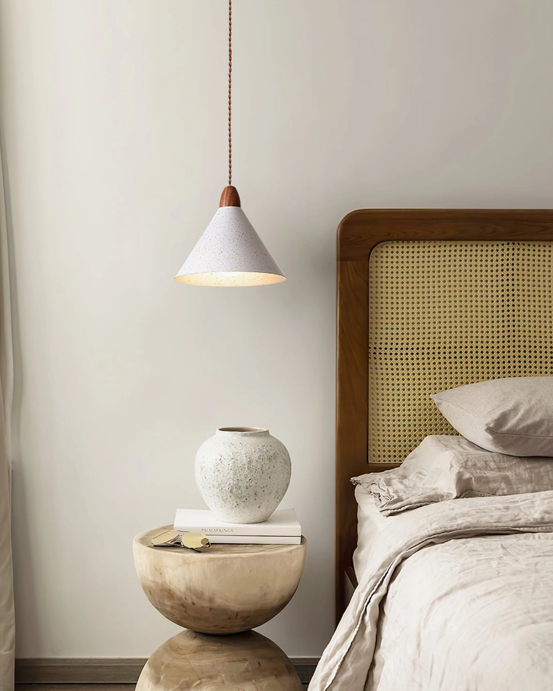 Anye pendant light in modern bedroom with rattan headboard and warm neutral minimalist interior