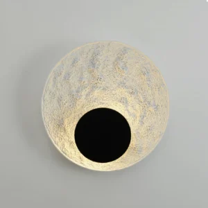 Apollo moon wall lamp illuminated warm glow textured surface close-up front view