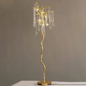 Aqua Babylonica brass floor lamp three-quarter view with warm LED lighting against gray wall interior