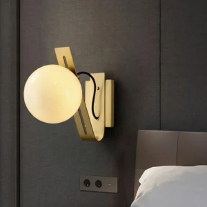 Burnished brass Arandela wall lamp in modern bedroom, warm ambient lighting on grey wall