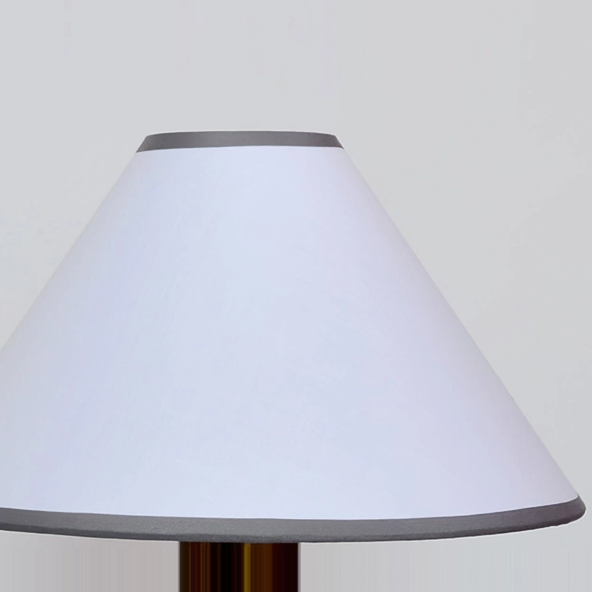 Arbol fabric lampshade detail close-up, white linen with gray trim accents, front view on neutral background