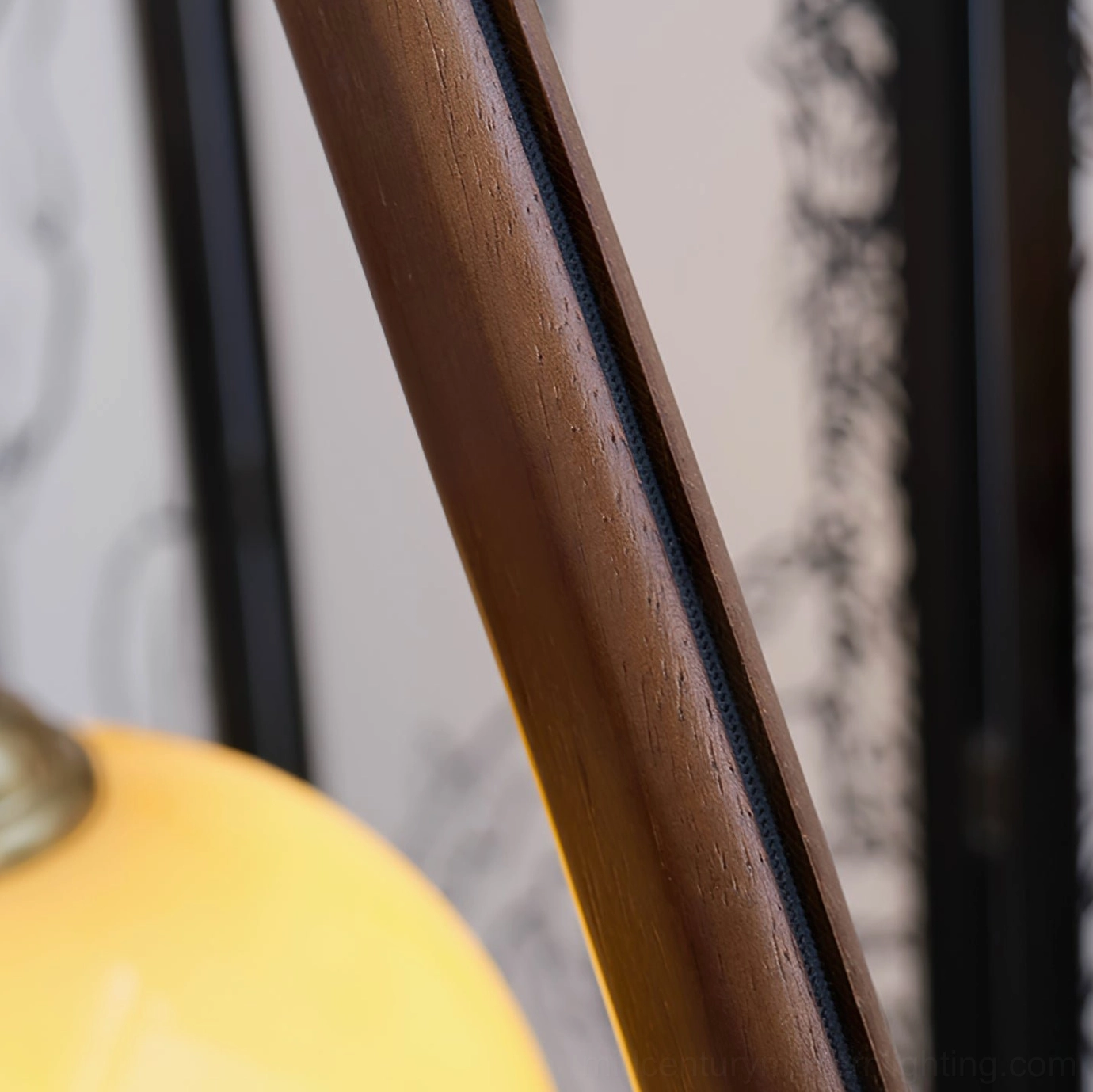 Close-up of arc lamp hardware, wooden pole grain detail, brass fixture and amber glass shade