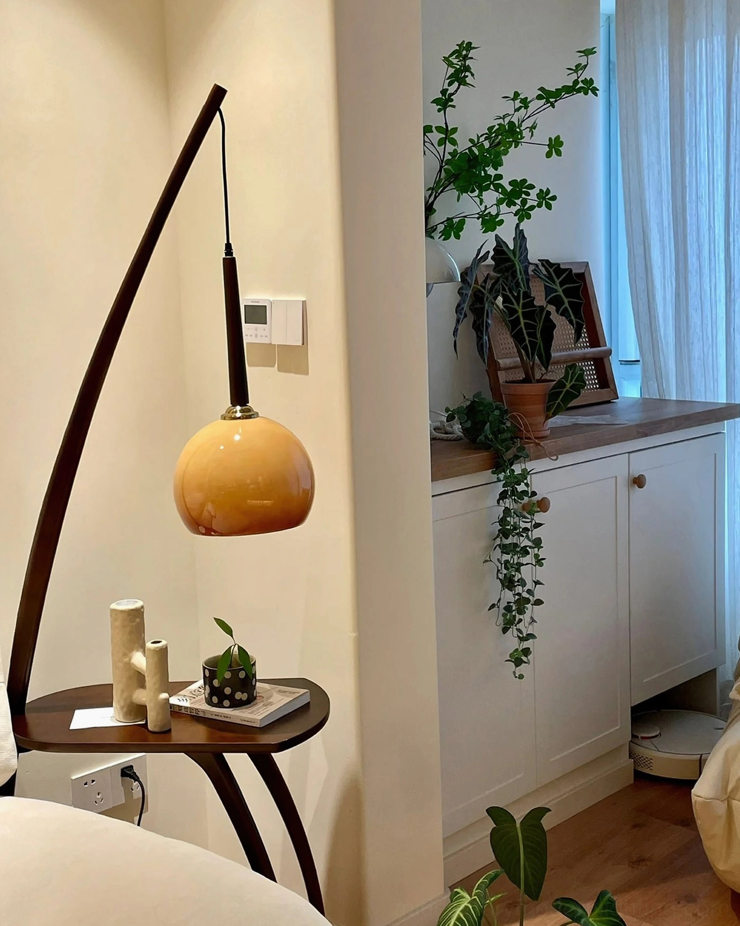 Arc floor lamp with integrated side table, warm amber lighting, mid-century modern home decor