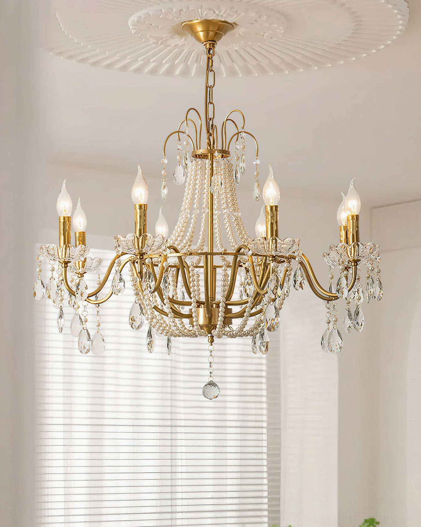 Arcadia crystal chandelier installed in traditional home with pearl beaded trim and lit candle bulbs, ceiling medallion