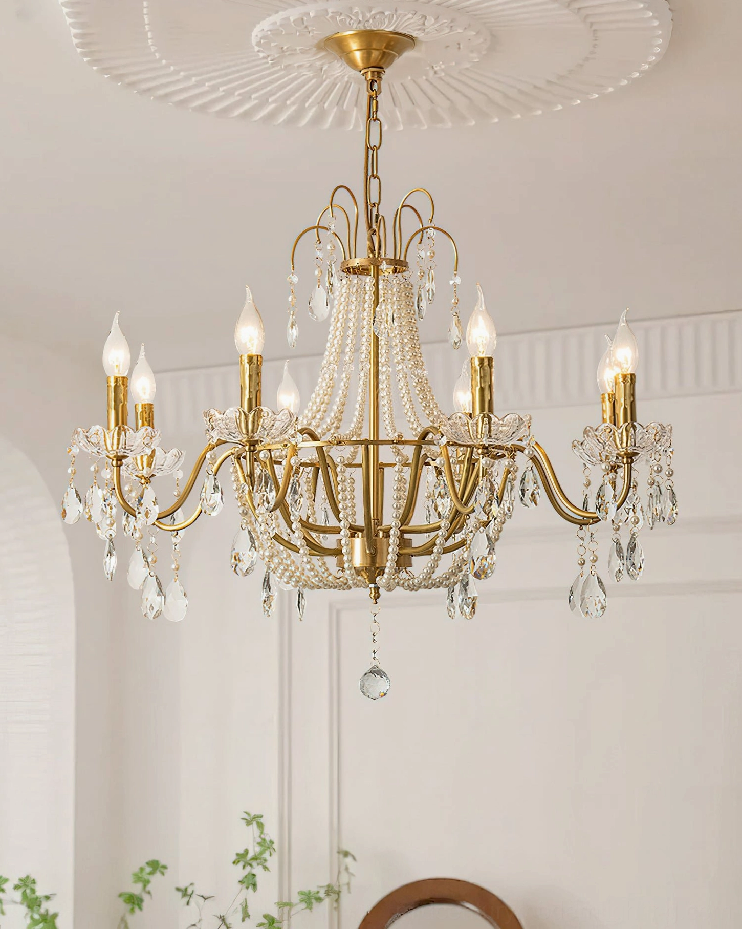 Arcadia crystal chandelier with clear hanging crystal accents in minimalist white interior with wall trim