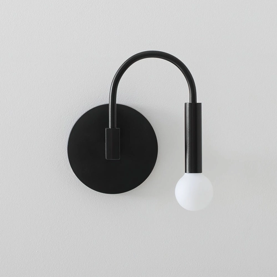 Arch wall lamp close-up detail shot showing frosted glass sphere and metal arm construction