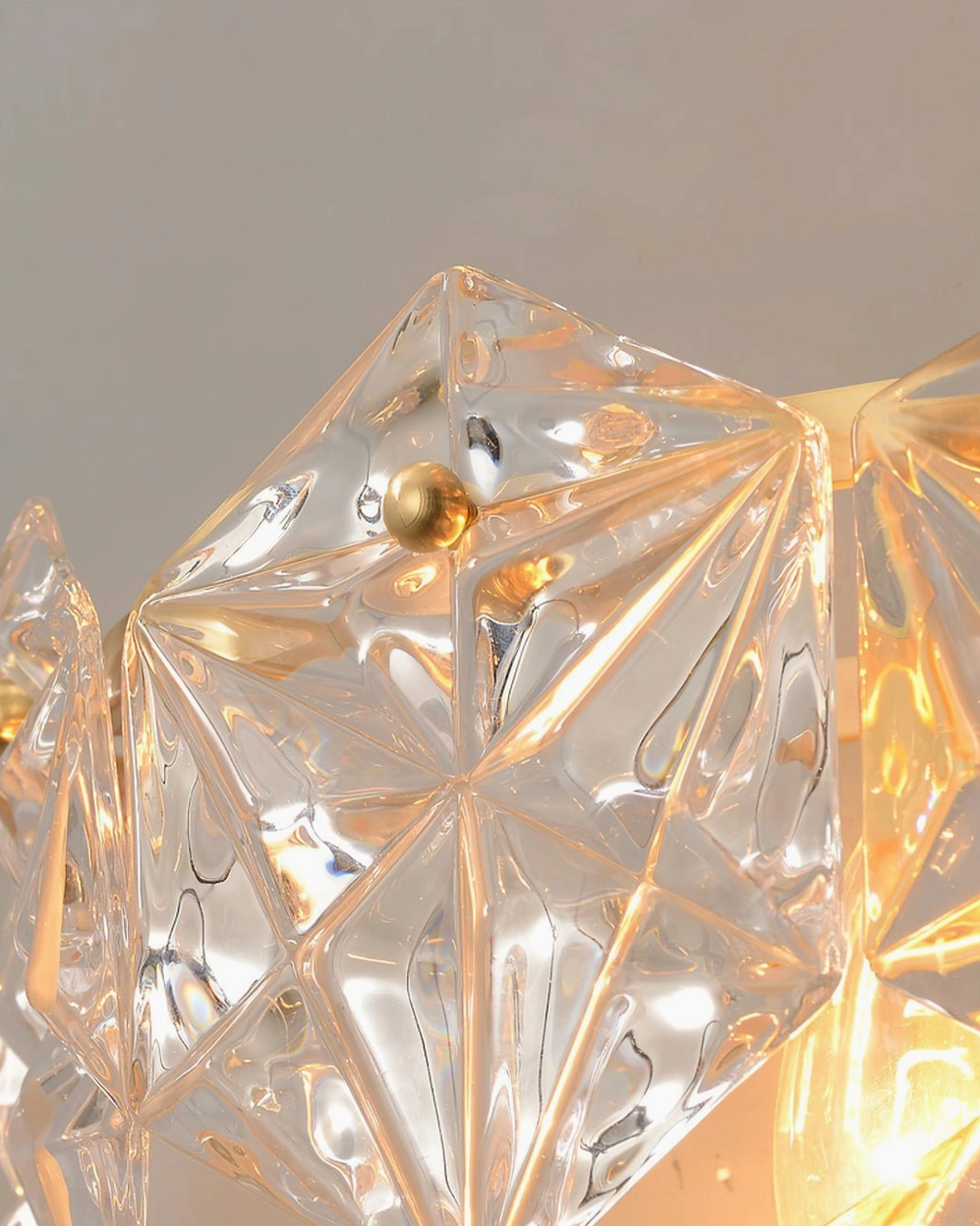 Geometric faceted crystal wall lamp architectural detail shot showing glass craftsmanship