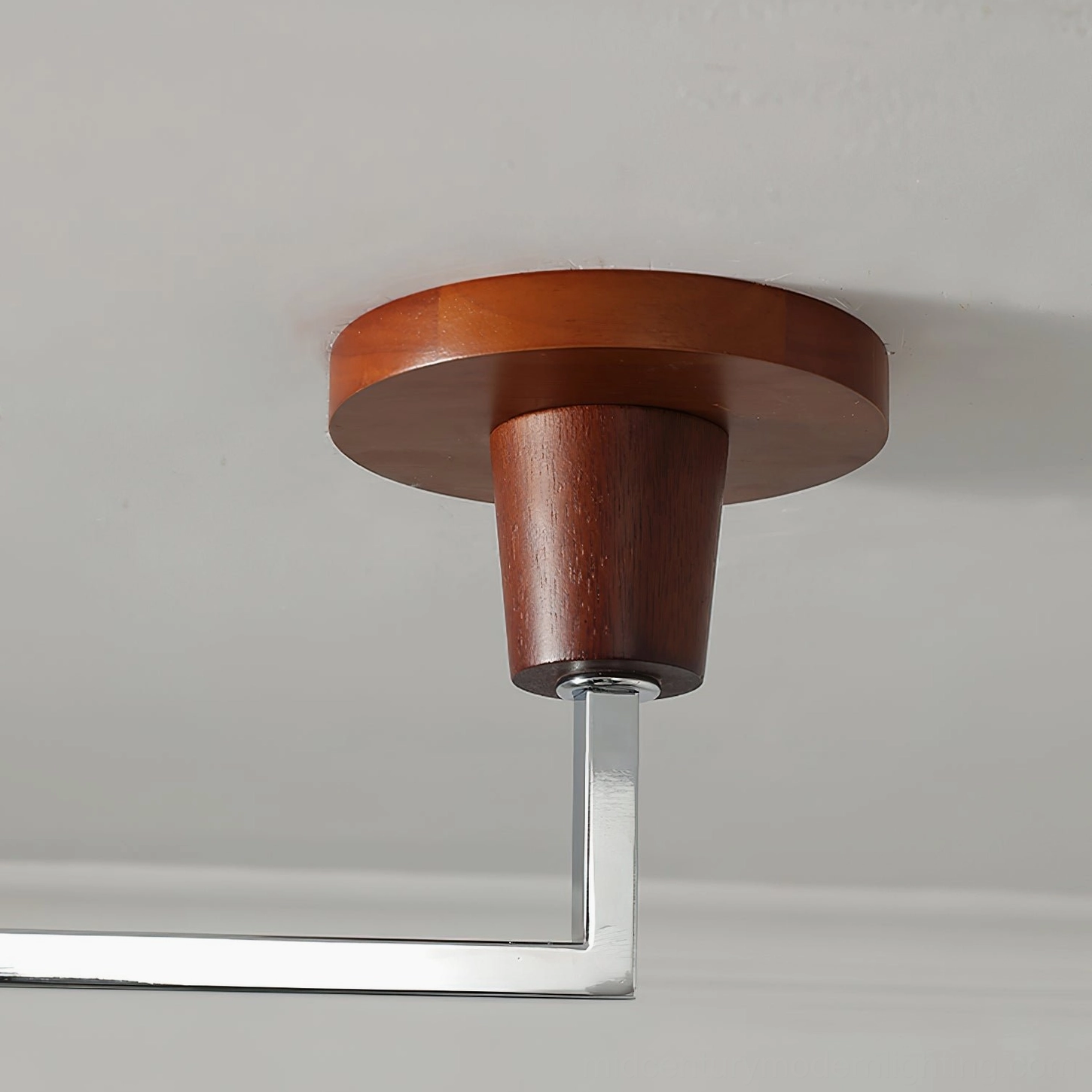Close-up of Arden ceiling mounting bracket featuring solid walnut wood base and silver metal arm