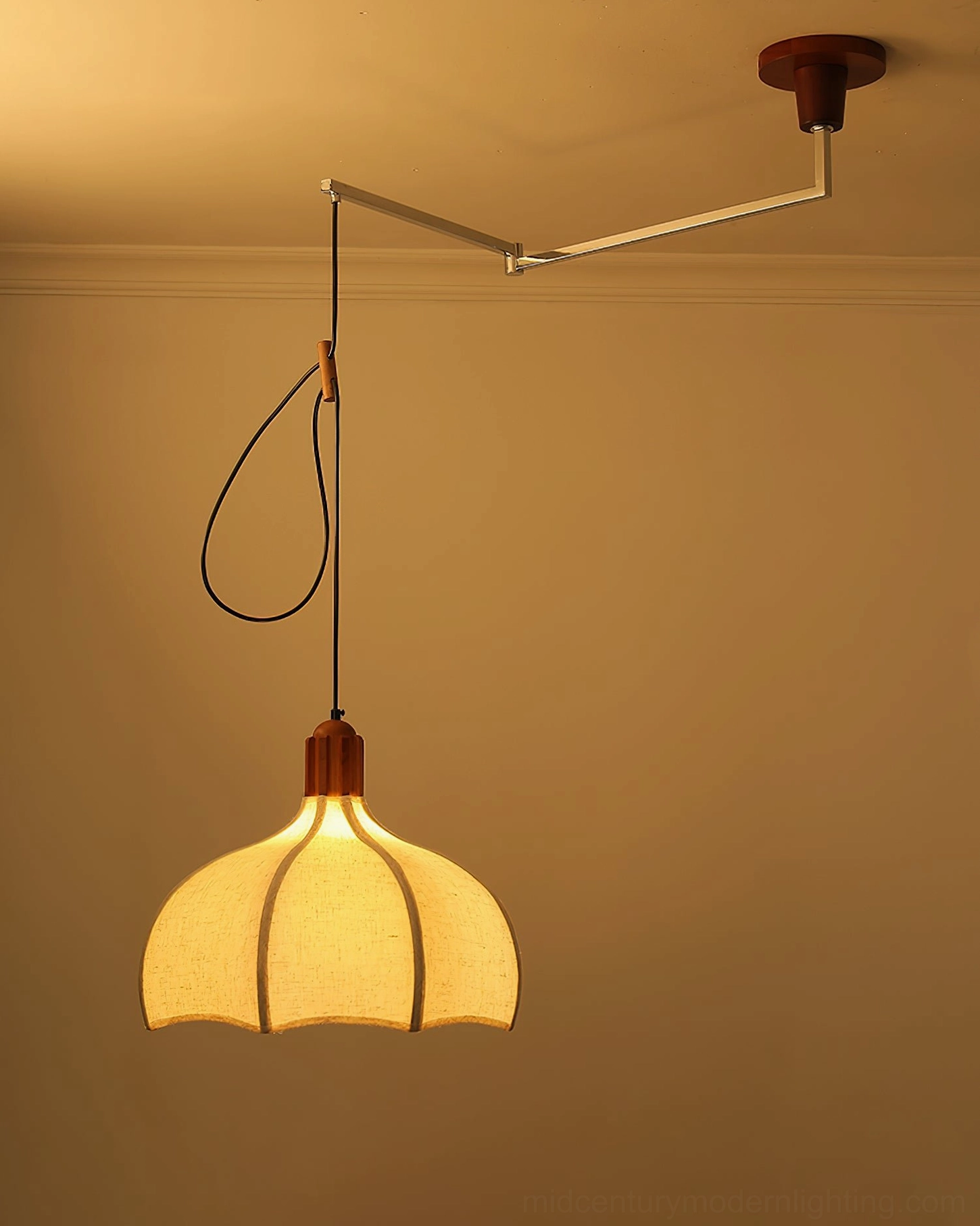 Arden swing arm pendant glowing warm illumination in interior setting with petal-shaped shade
