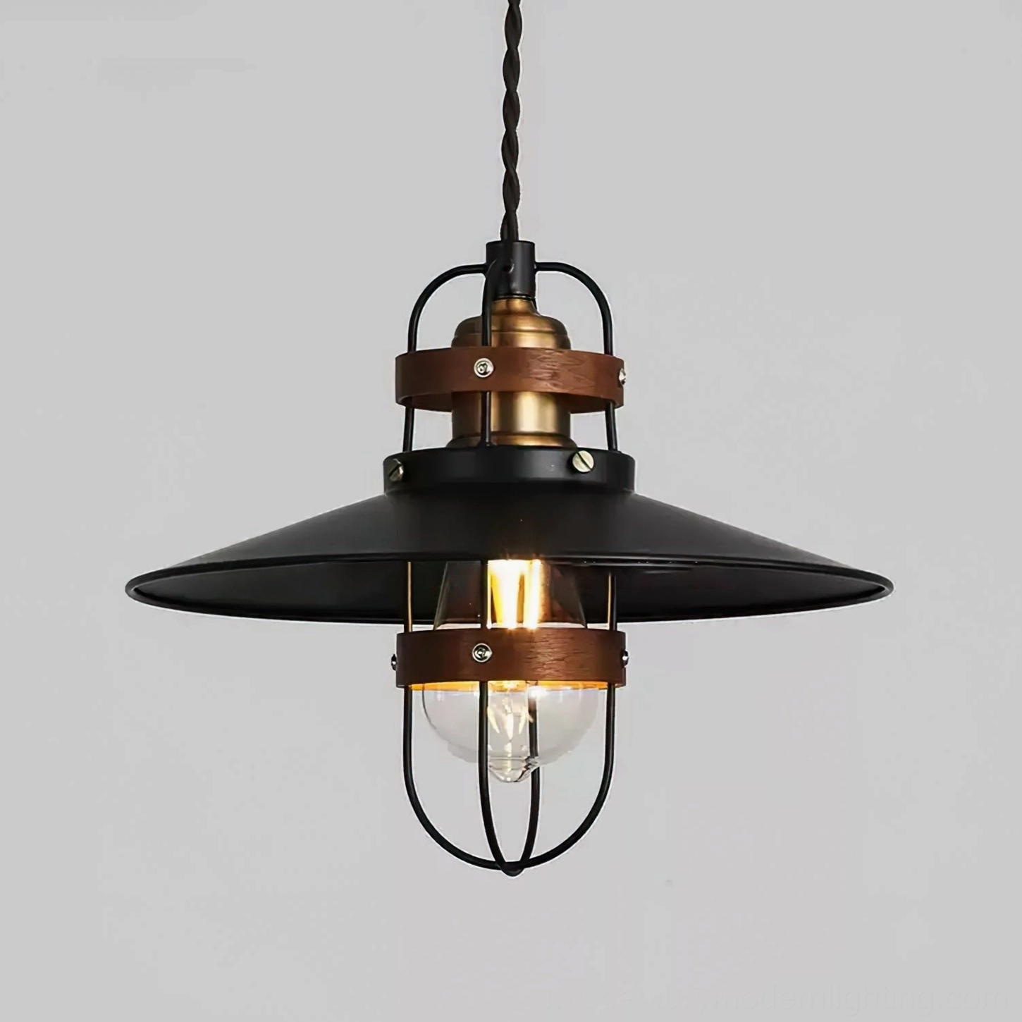Close-up detail of Arely pendant lamp showing exposed Edison bulb, twisted black cord, and protective metal guard cage construction