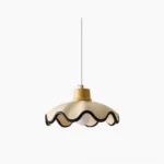 Arenal scalloped pendant light with black wavy trim shown hanging in studio light