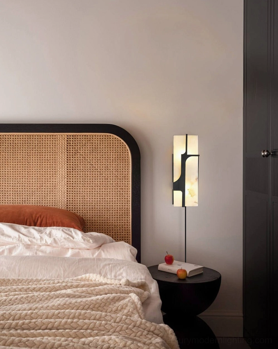 Ariel alabaster sconce bedside lamp in boho-modern bedroom with round nightstand and decorative fruit