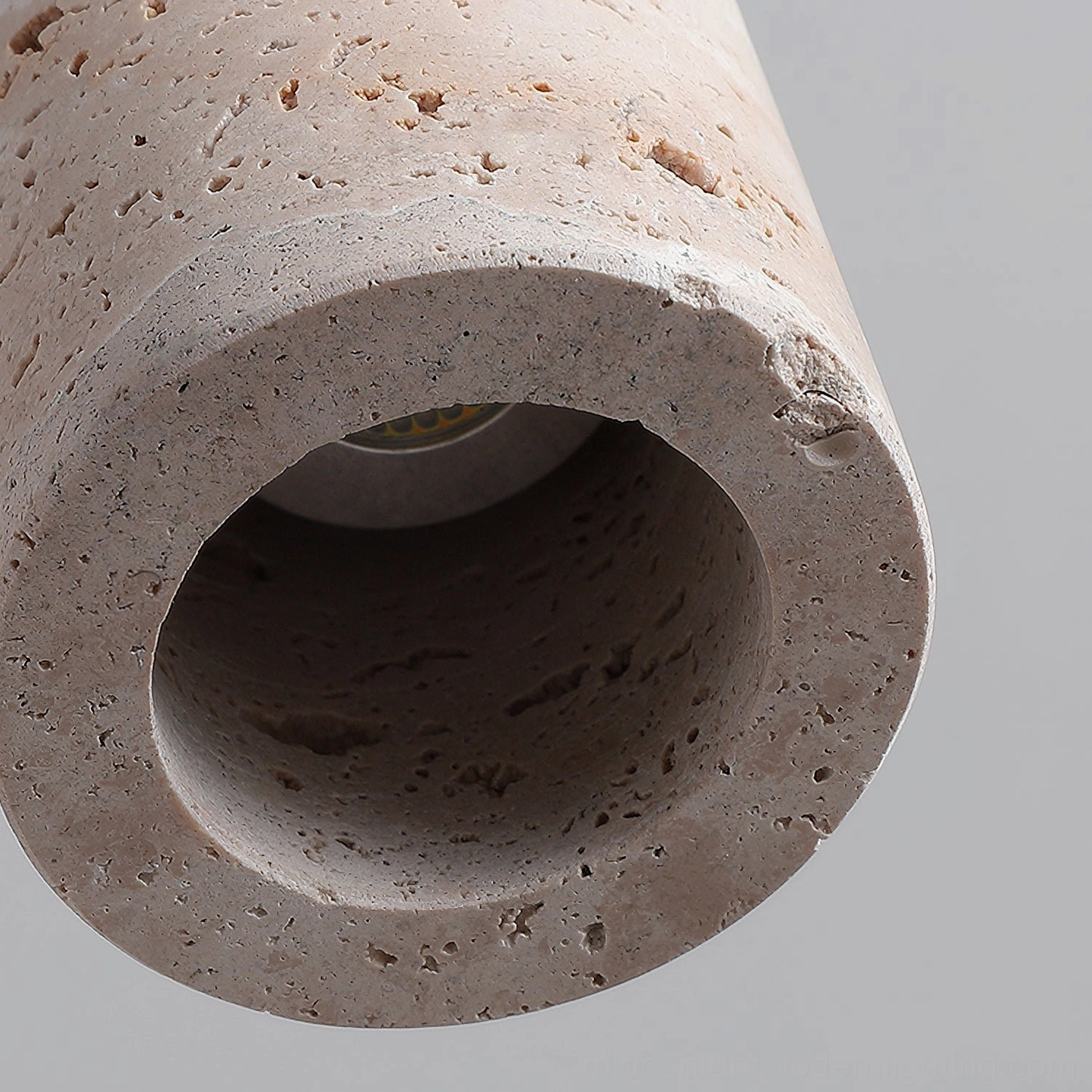 Multiple Arlene travertine pendant lights in staggered heights above dining or kitchen surface