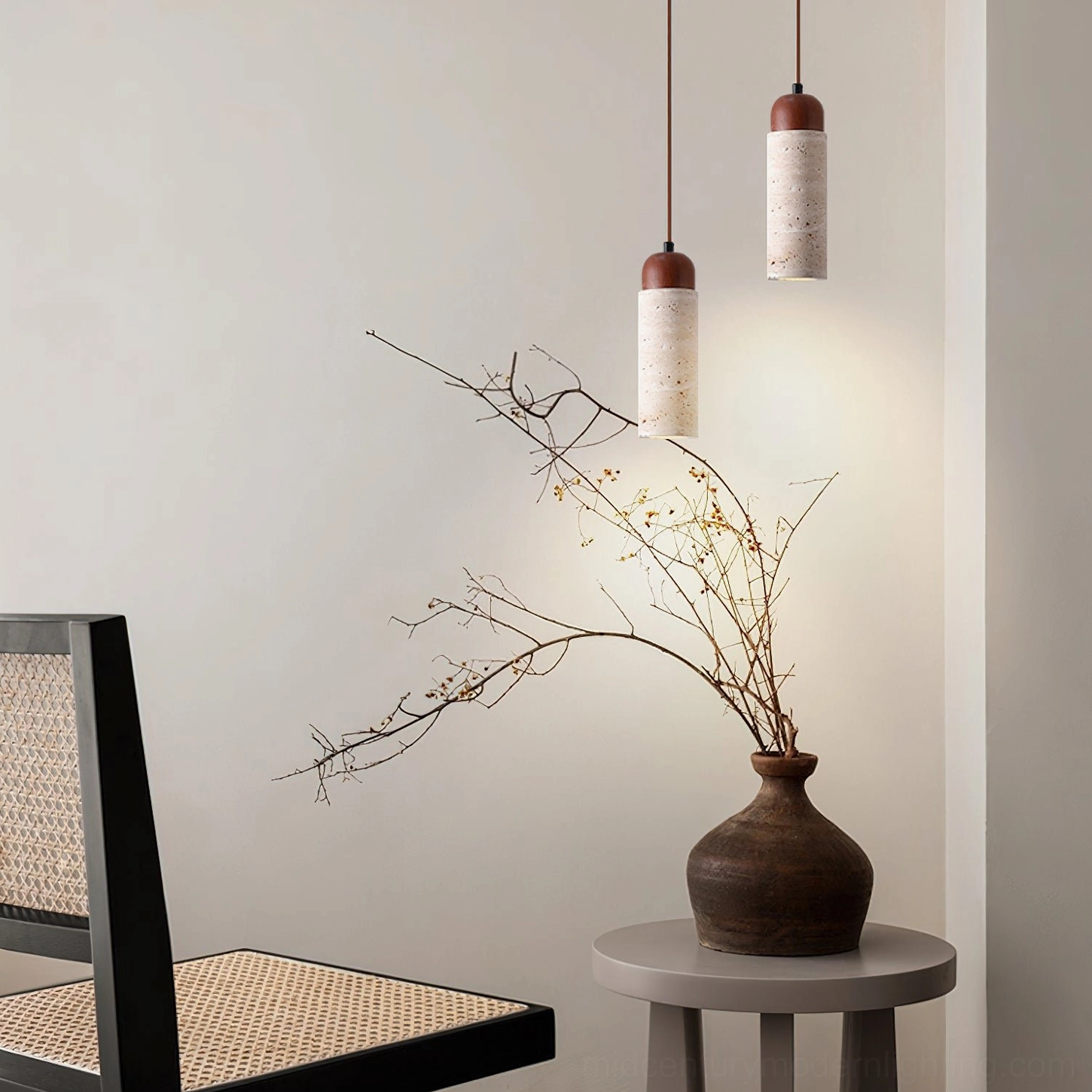 Pair of Arlene travertine pendant lights installed in minimalist living room with rattan furniture and neutral decor
