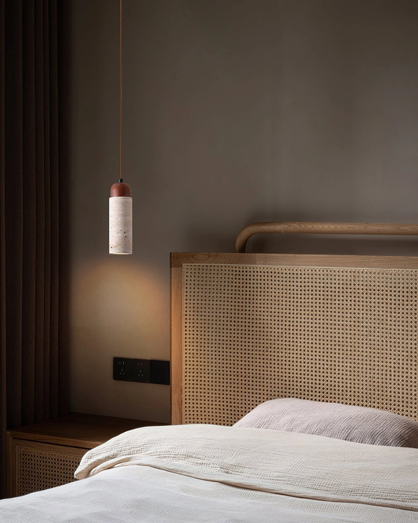 Cylindrical Arlene pendant with wooden accent in cozy bedroom with rattan headboard and warm lighting