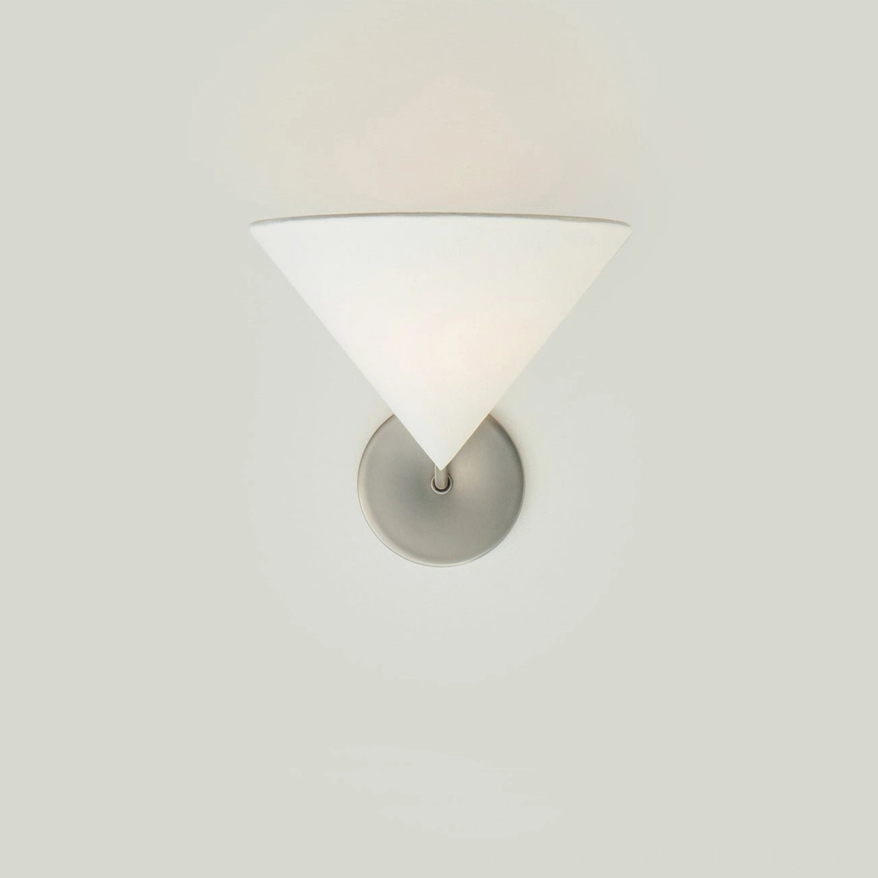 Arno wall sconce in brass with soft ambient glow, intimate bedroom reading nook lighting