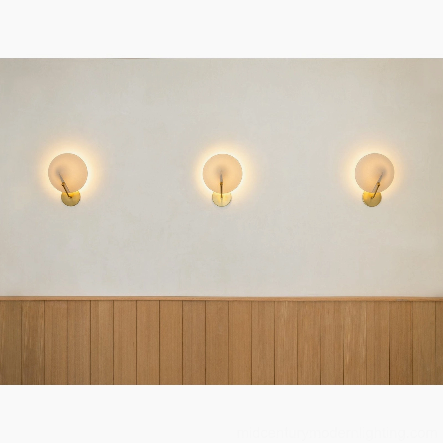 Set of three Arno mini globe wall sconces with matching brass bases in dining space with wainscot