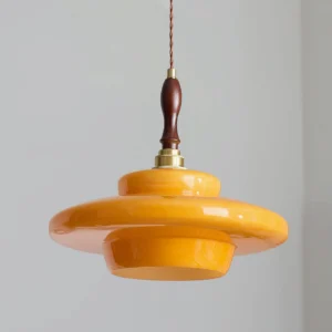 Close-up detail of Aroma pendant lamp showing polished brass fittings and turned walnut wood finial
