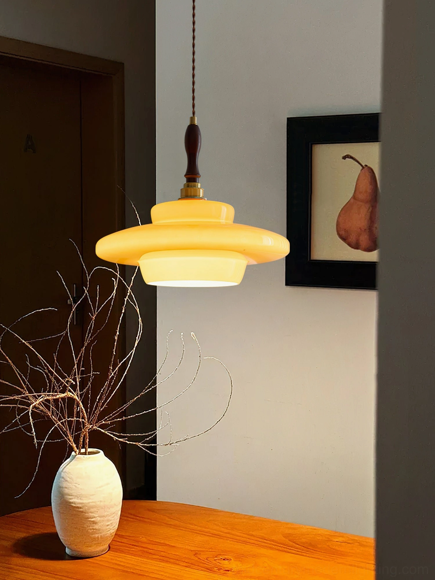 Aroma pendant lamp accent lighting in minimalist wooden dining corner with wall art and warm decor