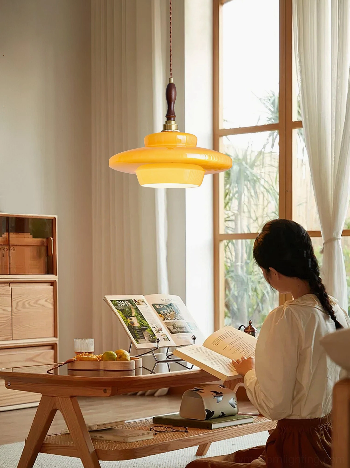 Warm amber glow from Aroma pendant lamp in sunlit mid-century modern living room with neutral styling