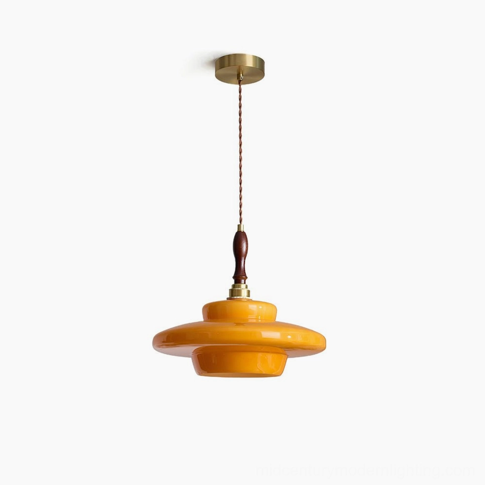 Aroma mid-century modern pendant lamp with layered amber glass shade and brass hardware in studio lighting