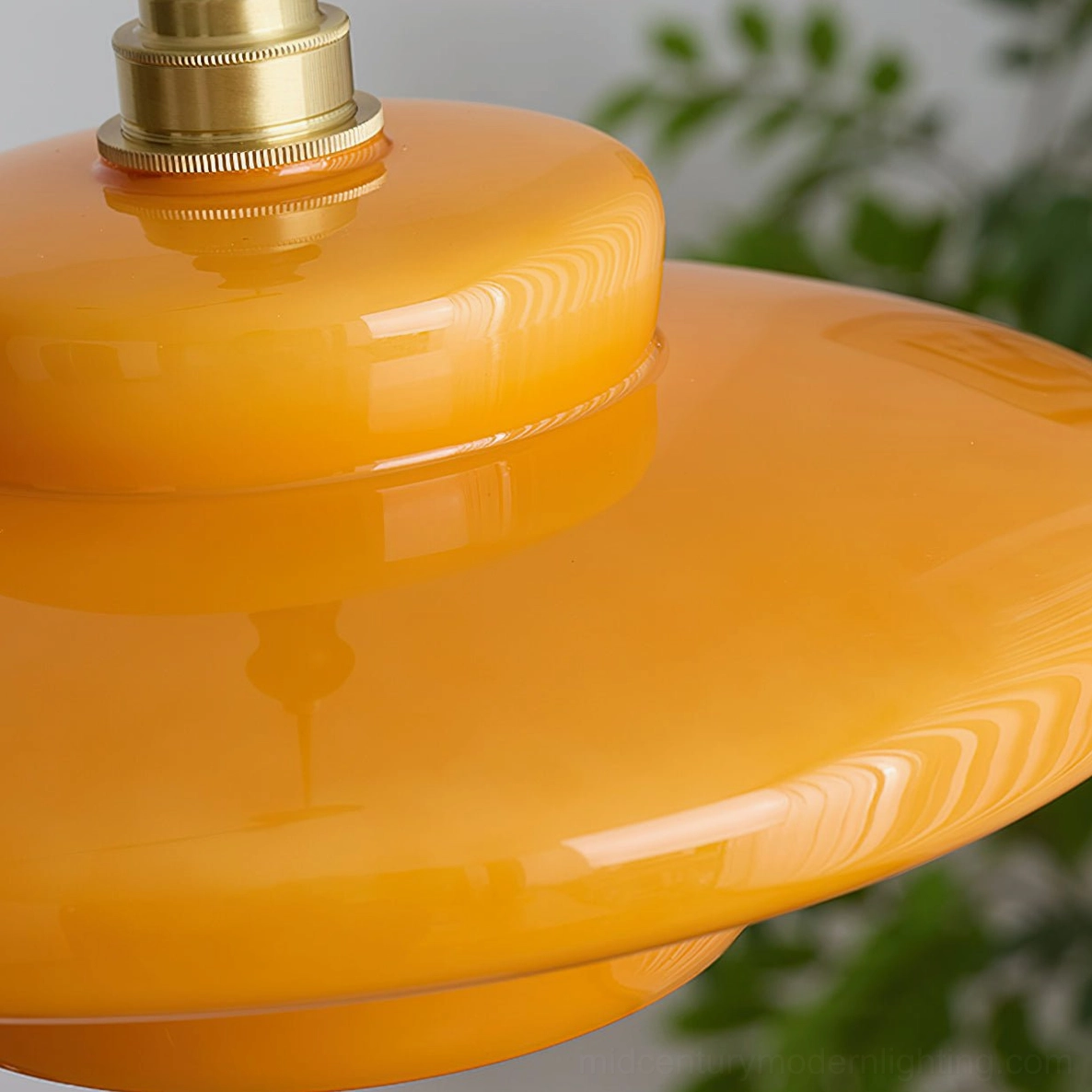 Aroma pendant lamp illuminated showing warm honeyed light cast through amber glass in interior space