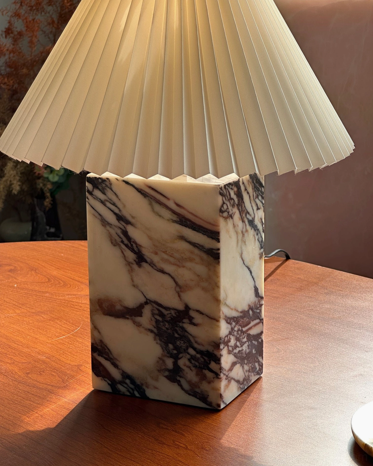 Arouca marble table lamp close-up featuring tall square base and wide pleated fabric shade