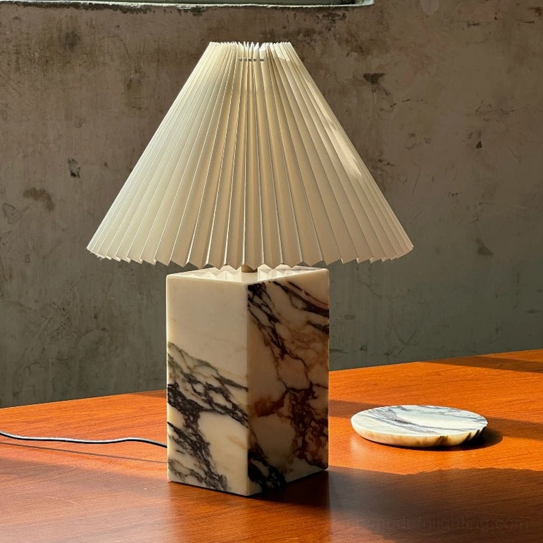 Arouca marble table lamp with natural veining on concrete wall backdrop in contemporary interior