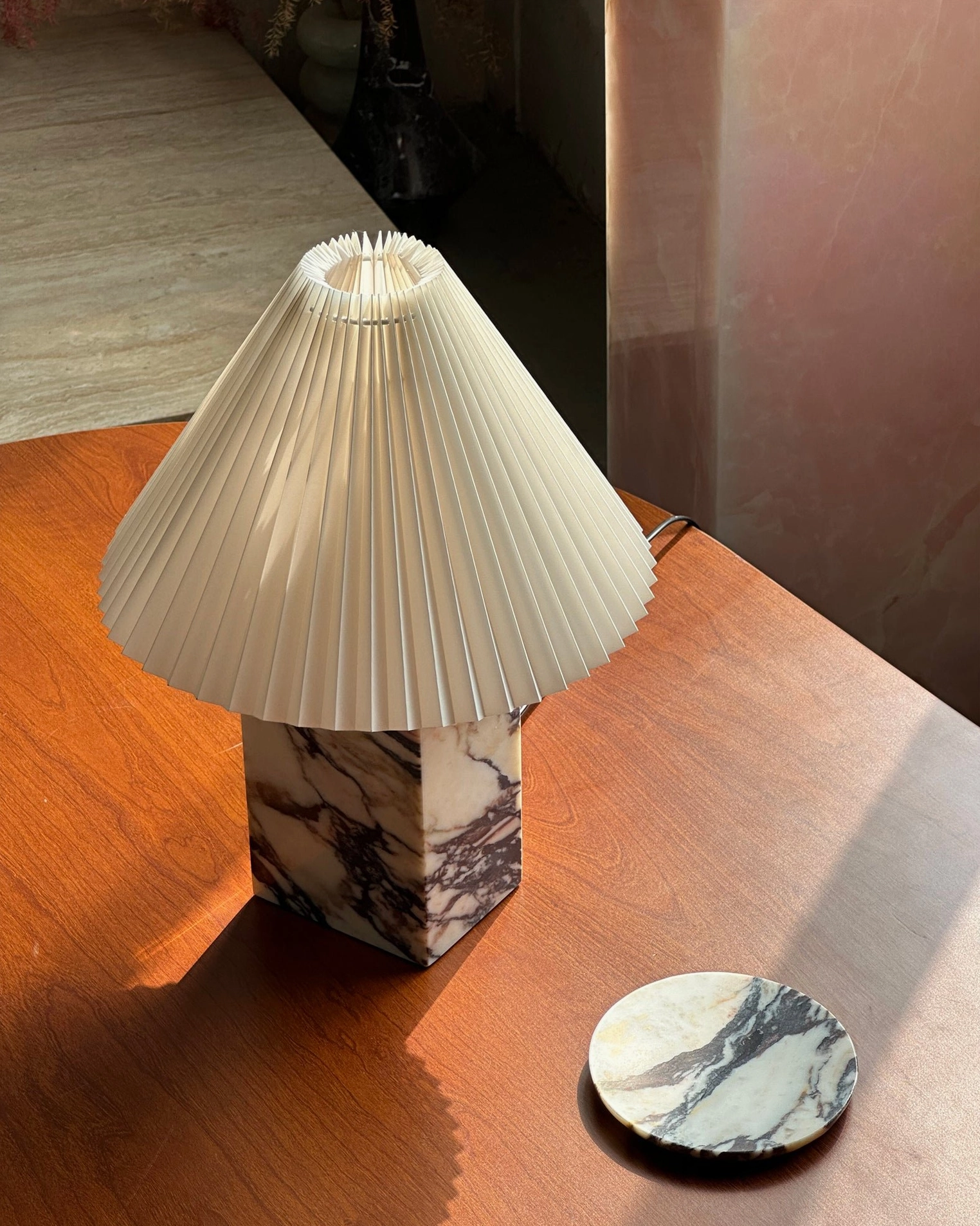 Overhead view of Arouca marble table lamp base with pleated shade on wooden dining surface