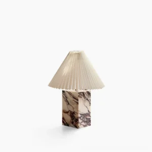 Arouca marble table lamp with purple-veined base and pleated fabric shade in minimalist studio setting