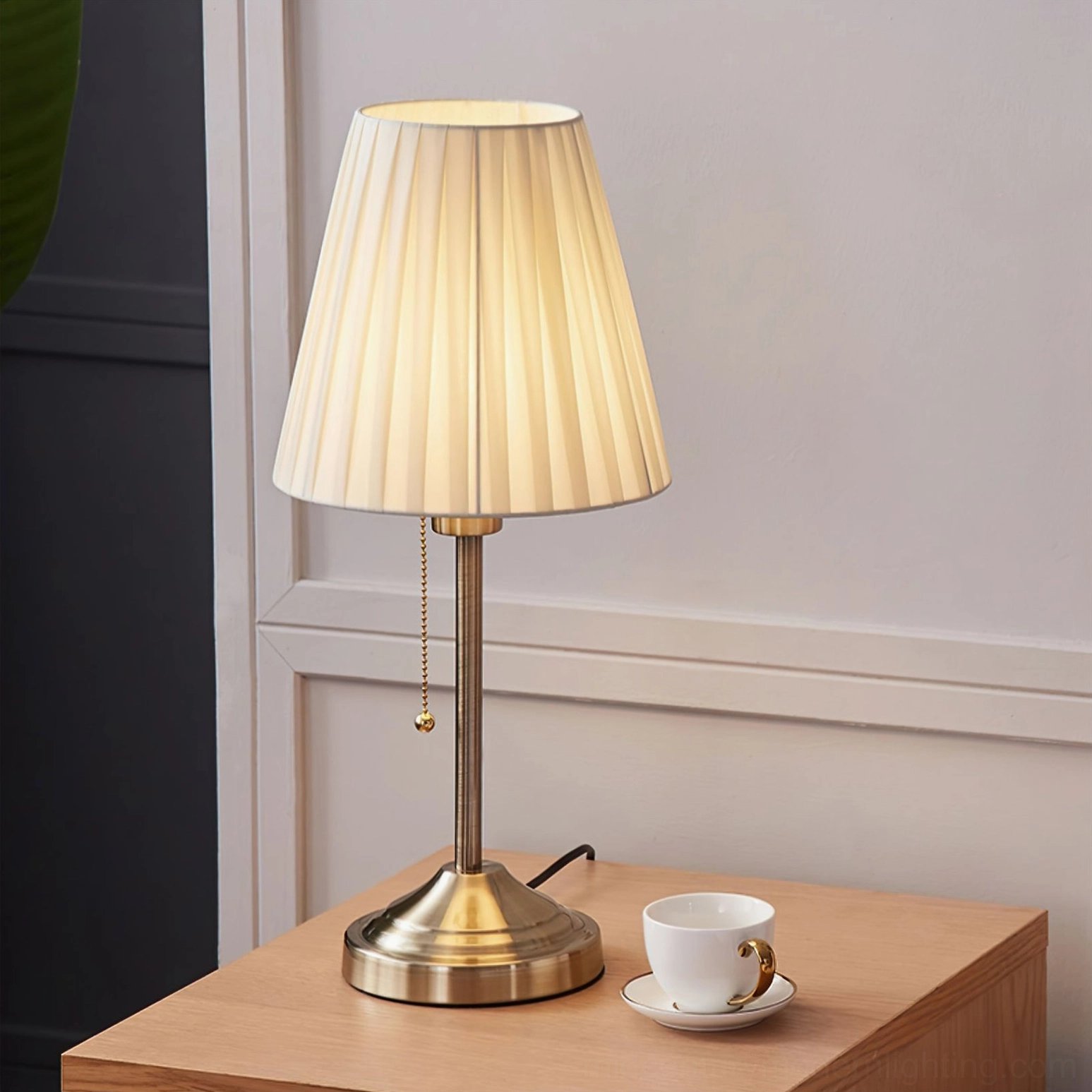 Arstid pleated shade table lamp on wooden bedroom nightstand with coffee cup and saucer