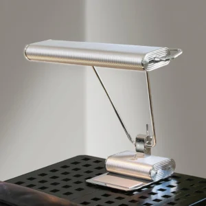 Art Deco 34 table lamp positioned on perforated metal side table demonstrating industrial-modern styling and dual adjustable arms