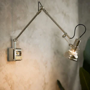 Close-up side view of dual-jointed articulating mechanism and industrial metal construction on textured concrete wall