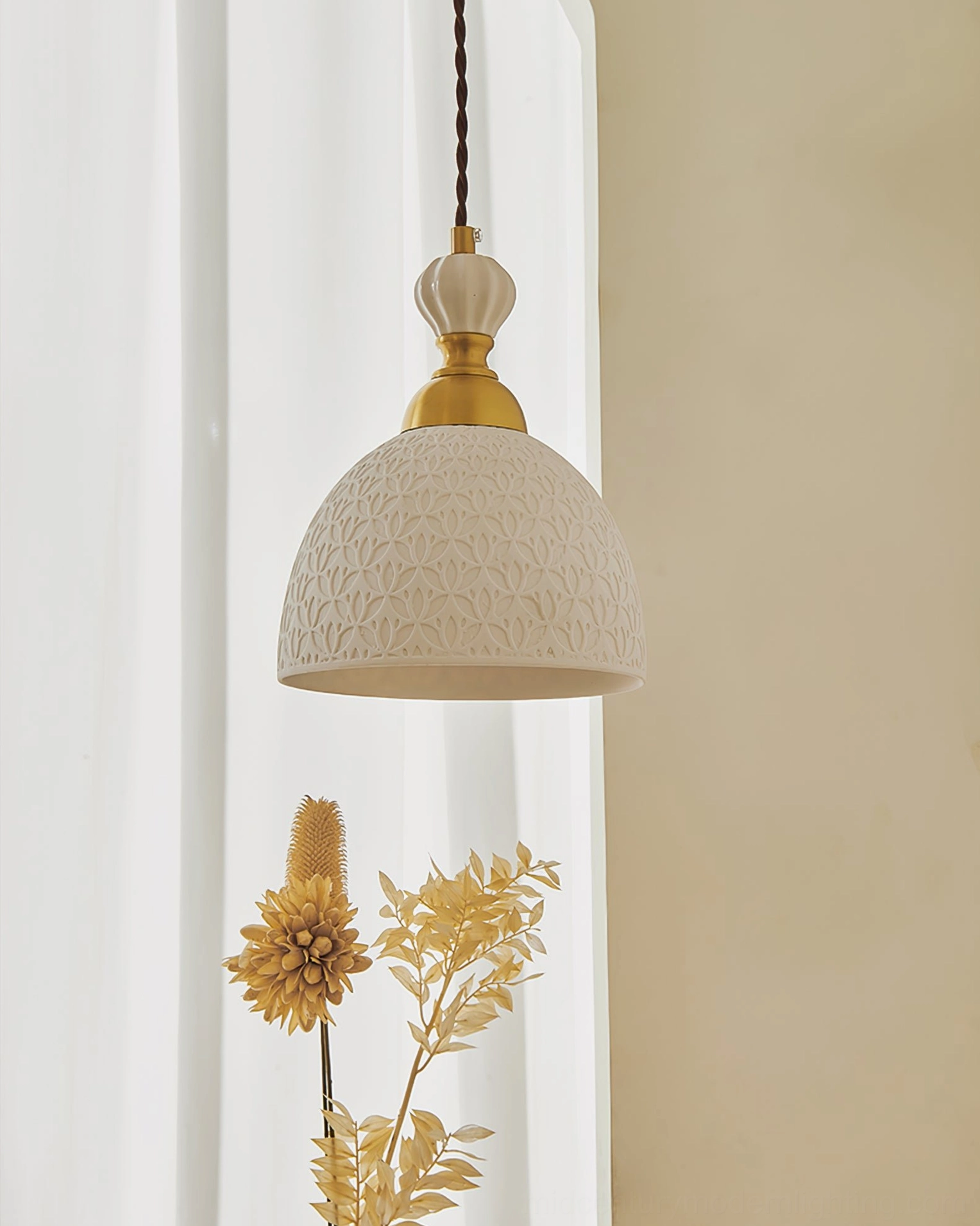 Domed white ceramic pendant light with textured surface and brass gold top fixture and dried florals