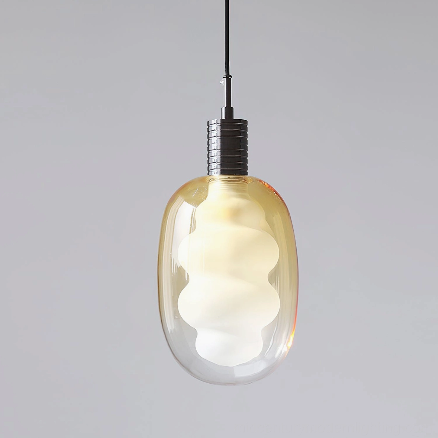 Pendant light with artistic glass form, brass metal top detail, contemporary lighting sculpture