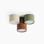 Asher modular ceiling drum lights in three finishes: cream, sage green, and warm coffee brown, arranged as a tri-color color-block cluster on white studio background