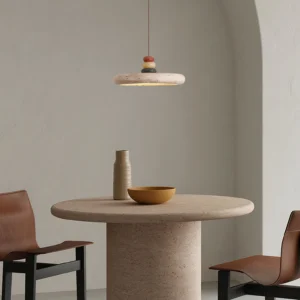 Yellow travertine sculptural pendant light above minimalist dining table with modern chairs - low angle view