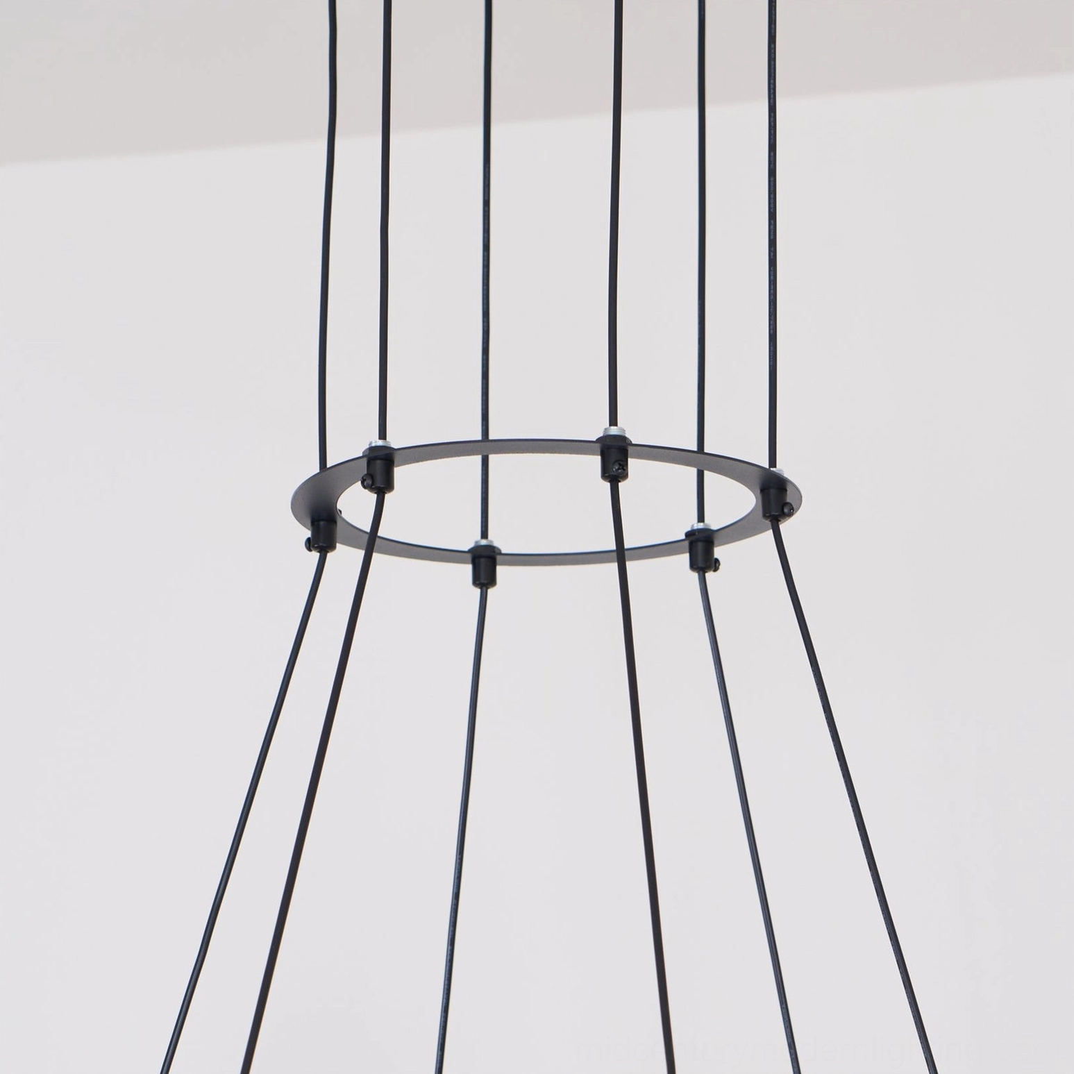 Astra pendant chandelier with frosted glass globe shades and black metal fixtures, architectural detail view