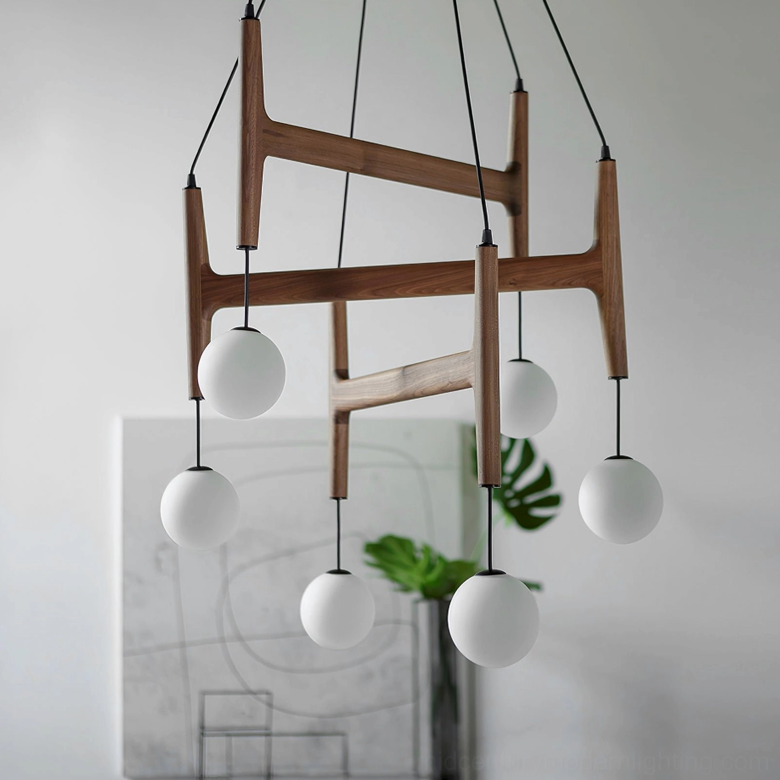 Astra wooden chandelier with black suspension wires and frosted glass shades, close-up detail with indoor plant decor