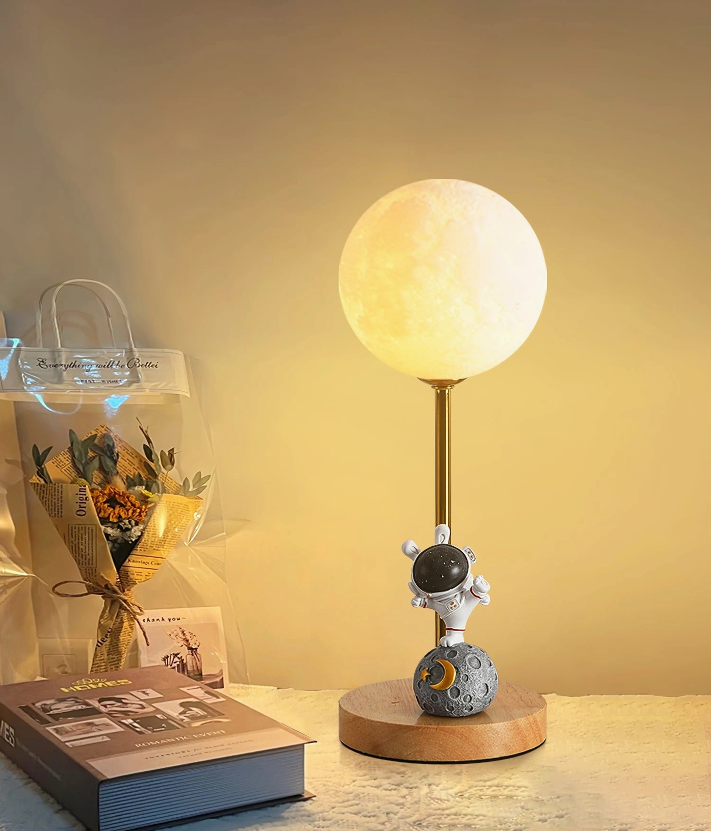 Astronaut moon table lamp powered on creating ambient bedroom lighting next to fresh flowers and modern nightstand