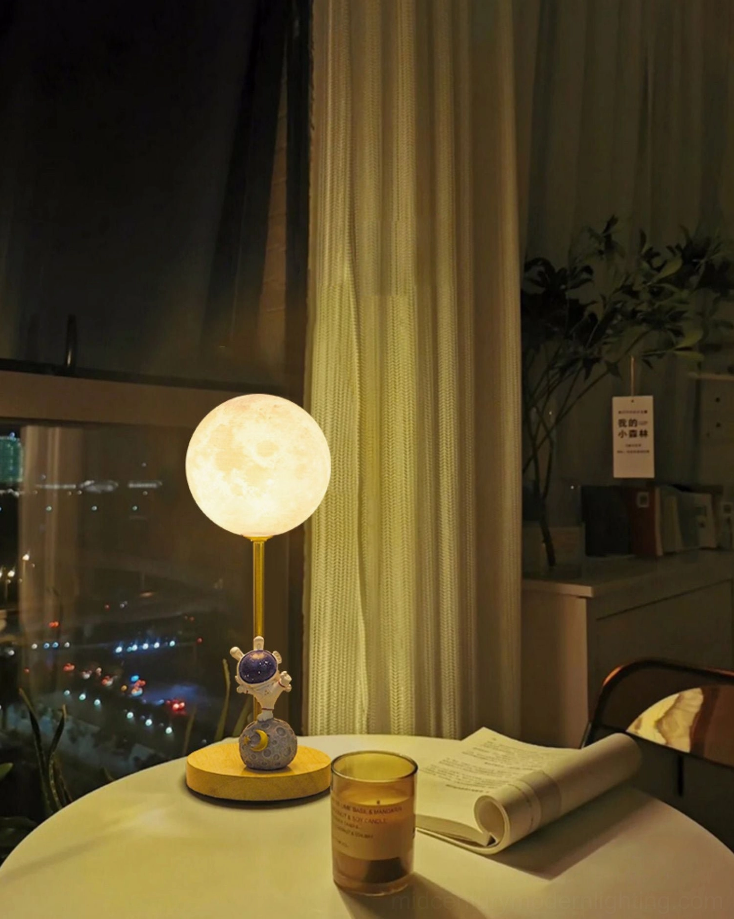 Astronaut moon table lamp on dining table at night with warm glow and city window view in background apartment interior
