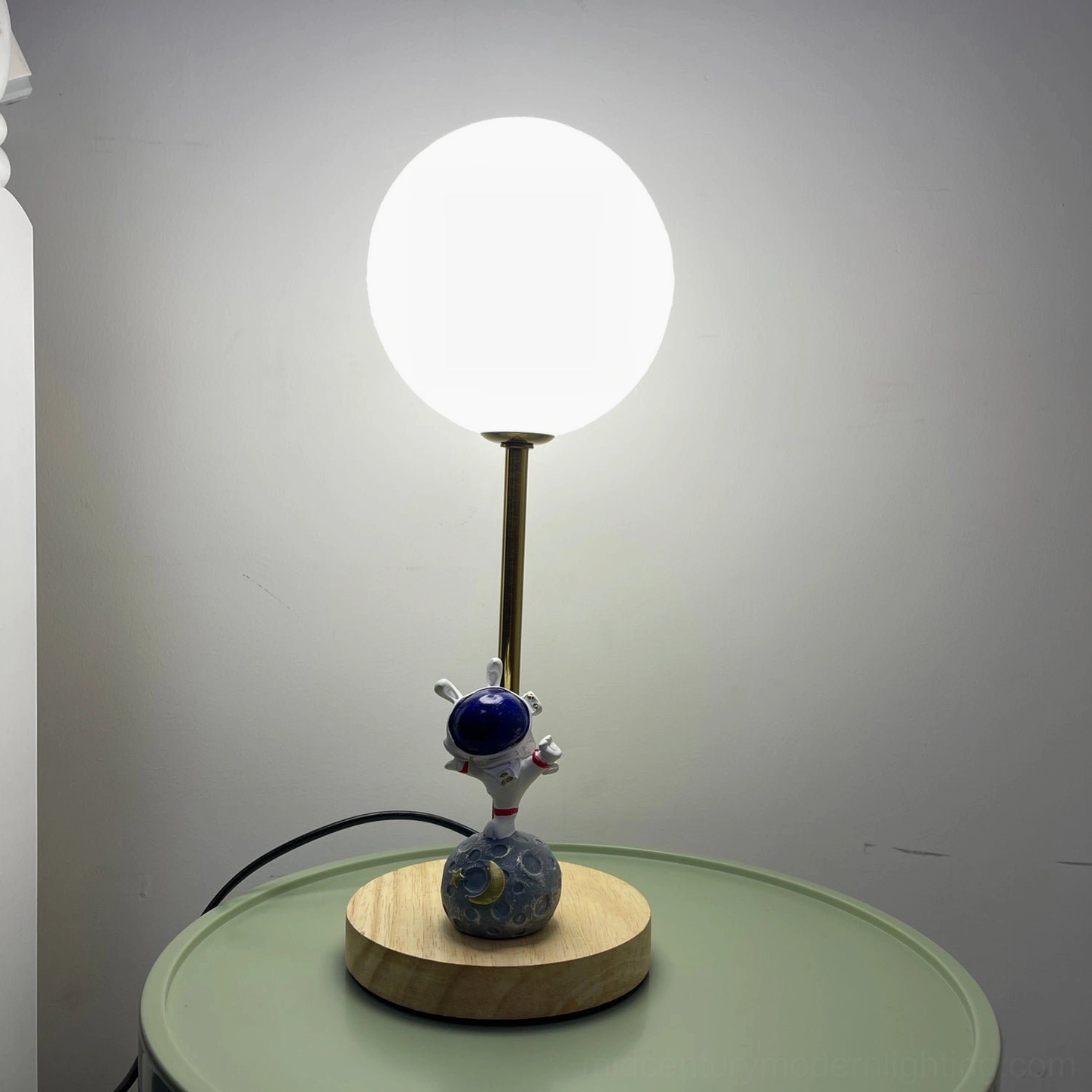 Astronaut moon table lamp in eclectic bohemian home decor setting with vintage accessories and natural elements