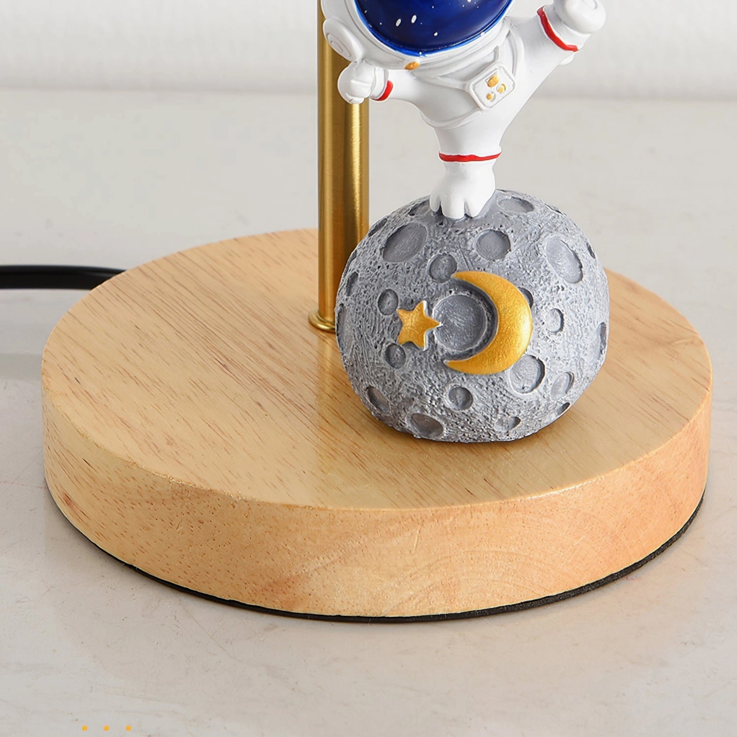 Top-down close-up of astronaut moon lamp base showing crescent moon and star decorative details on white background