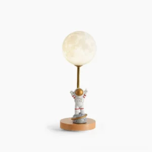Astronaut moon table lamp with wooden base and LED light, front studio view showing detailed resin astronaut figurine and white lampshade on white background